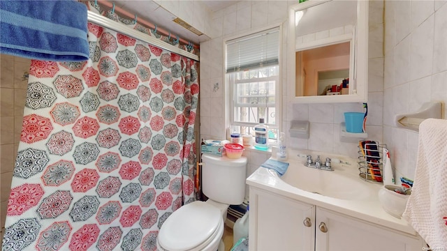 bathroom featuring vanity, toilet, tile walls, and walk in shower