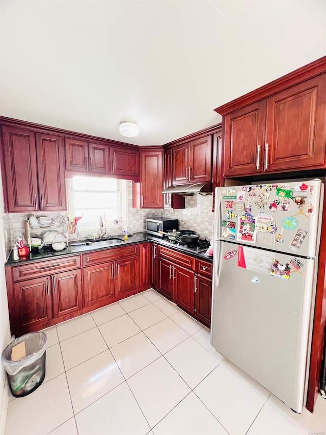 kitchen featuring appliances with stainless steel finishes, backsplash, light tile patterned floors, and sink