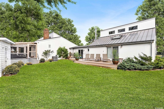 back of house with a sunroom, a yard, central AC unit, and a deck