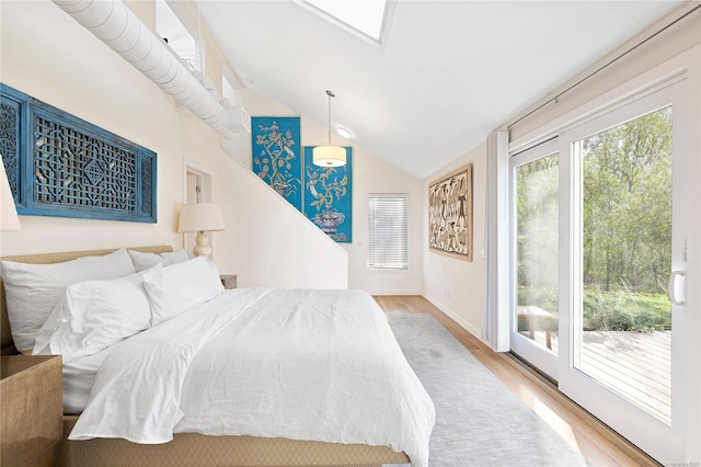 bedroom featuring access to exterior, light hardwood / wood-style flooring, and lofted ceiling