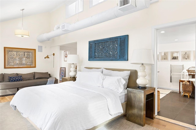 bedroom featuring high vaulted ceiling and wood-type flooring