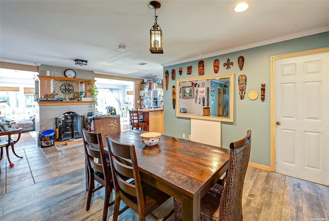 dining room with a healthy amount of sunlight, crown molding, and light hardwood / wood-style flooring