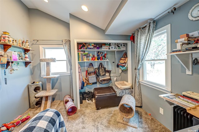 carpeted bedroom featuring radiator heating unit and lofted ceiling