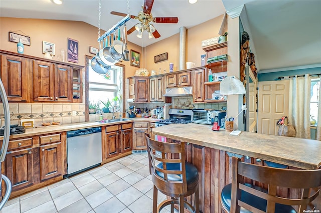 kitchen with tasteful backsplash, a wealth of natural light, a kitchen bar, and appliances with stainless steel finishes