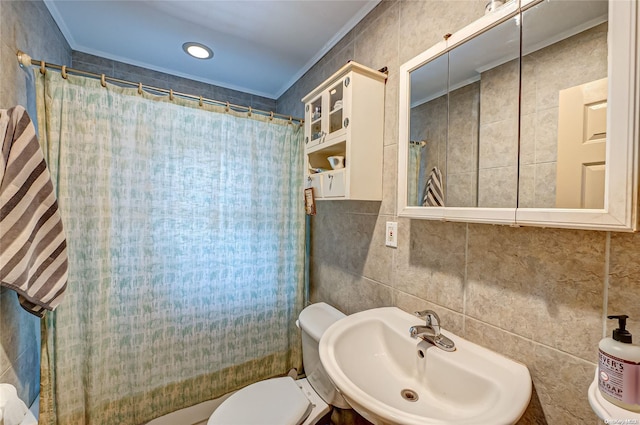 bathroom with toilet, sink, ornamental molding, and tile walls