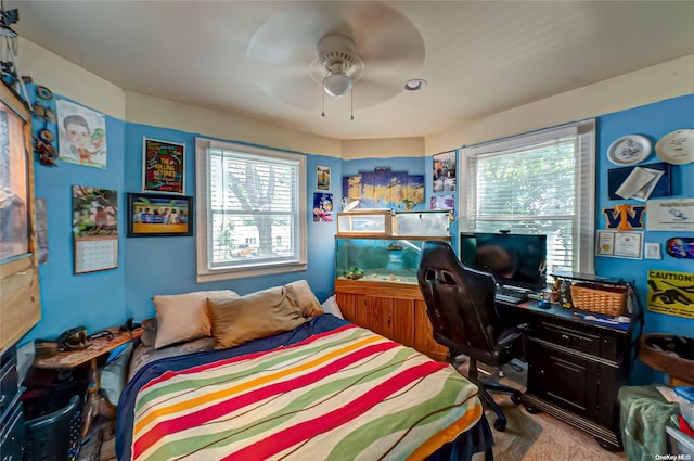 carpeted bedroom featuring multiple windows and ceiling fan