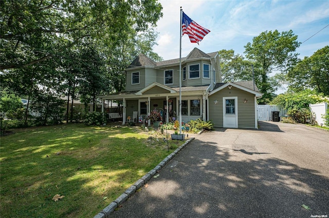 victorian-style house with covered porch and a front lawn