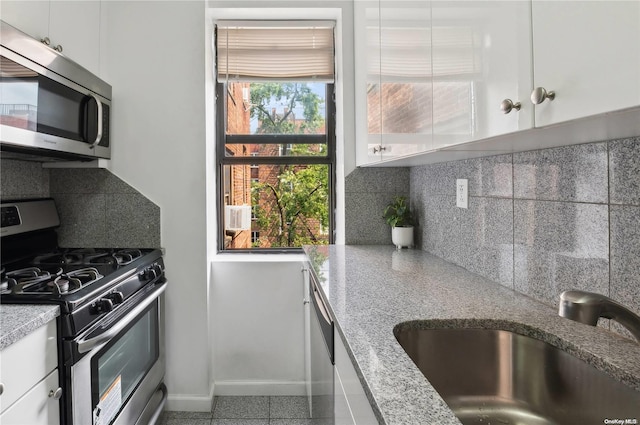 kitchen with decorative backsplash, sink, white cabinets, and appliances with stainless steel finishes