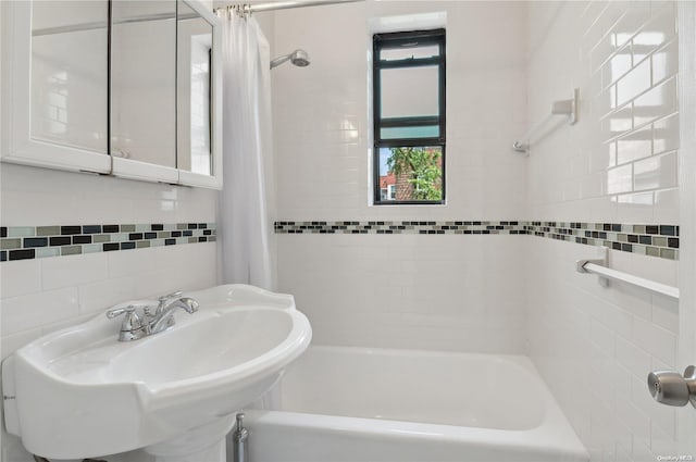 bathroom with sink, shower / bath combo, and tile walls