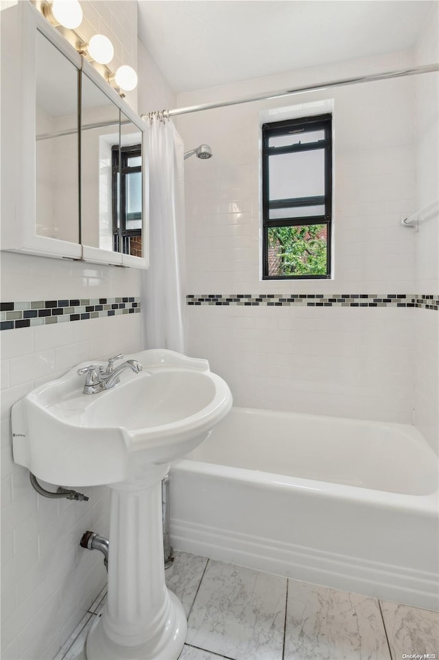 bathroom with shower / bath combo with shower curtain and tile walls