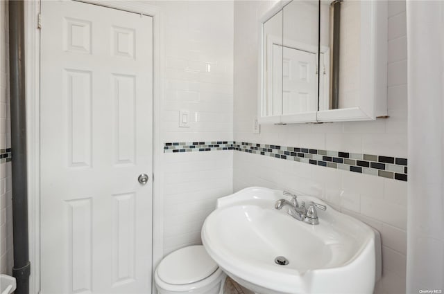 bathroom with sink and tile walls