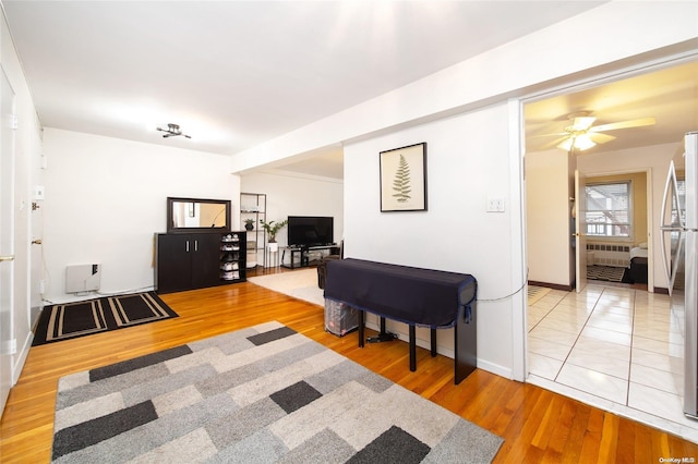 living room with heating unit, ceiling fan, hardwood / wood-style floors, and radiator heating unit