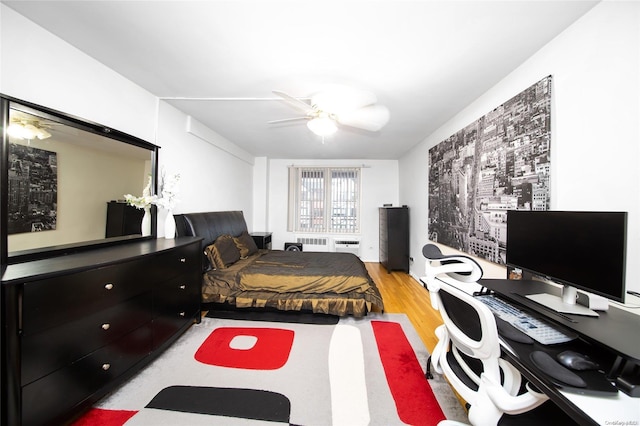 bedroom with ceiling fan, light hardwood / wood-style flooring, and radiator heating unit