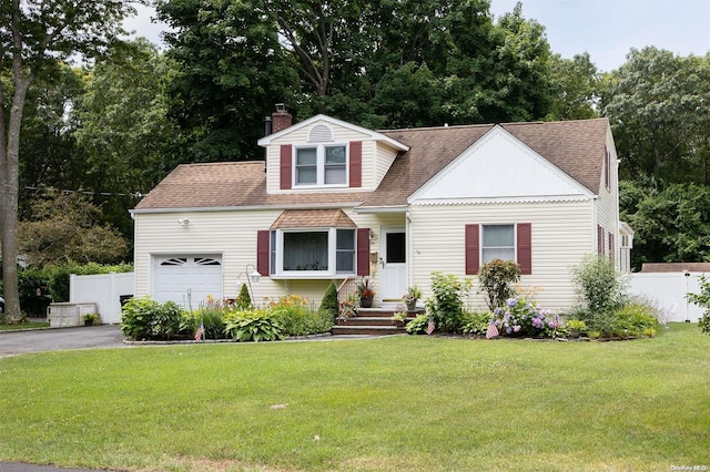 view of front of property with a front yard and a garage