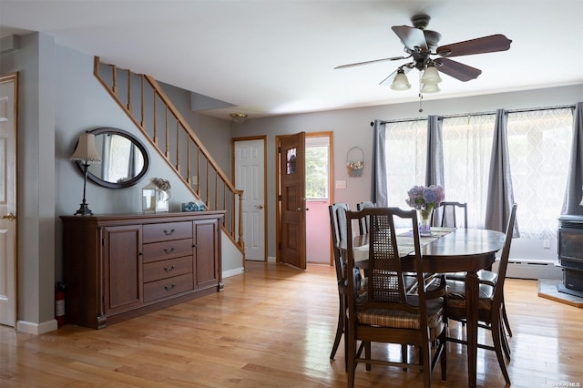 dining space with ceiling fan, light hardwood / wood-style floors, and a baseboard heating unit