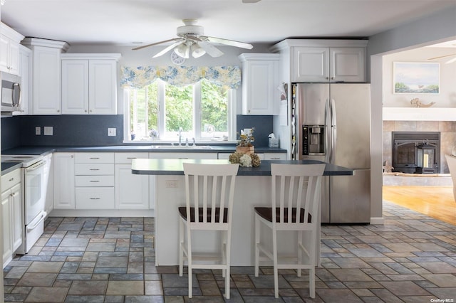 kitchen with white cabinets, a kitchen breakfast bar, sink, and stainless steel appliances