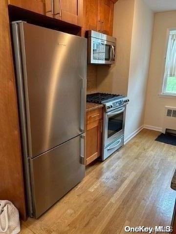 kitchen with stainless steel appliances and light hardwood / wood-style floors