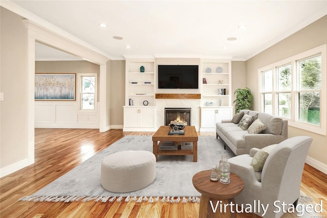 living room featuring crown molding and light hardwood / wood-style flooring