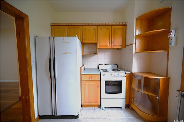 kitchen with light tile patterned floors, white appliances, and tasteful backsplash