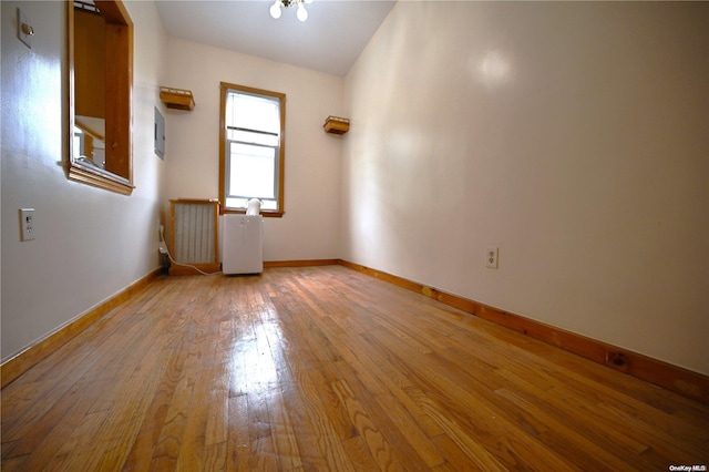 empty room with radiator and light wood-type flooring