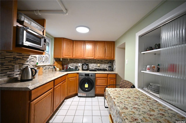 kitchen featuring decorative backsplash, washer / dryer, and light tile patterned floors