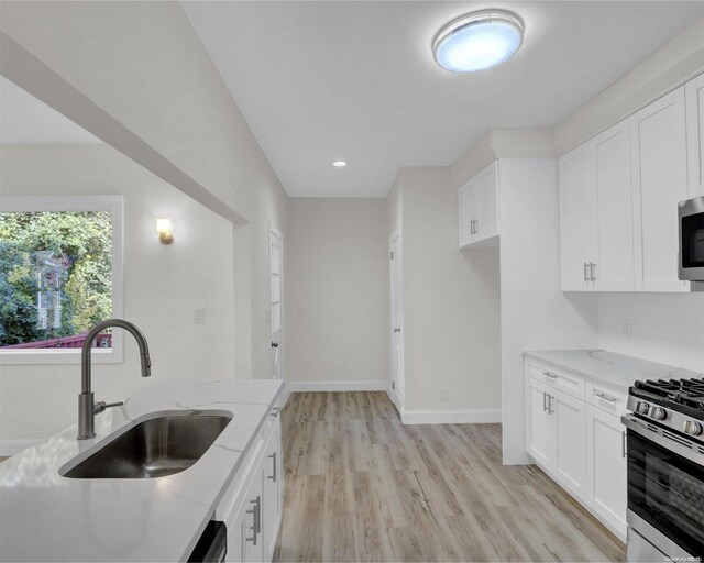 2 Oak Ct, Staten Island, NY 10308 - kitchen featuring a sink, light stone countertops, appliances with stainless steel finishes, light wood-type flooring, and white cabinets