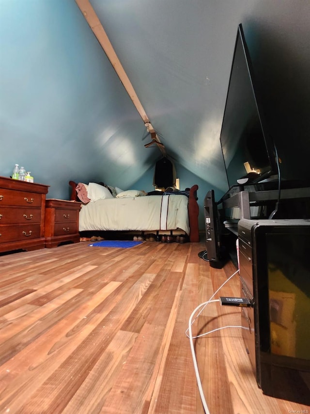 bedroom featuring light wood-type flooring and vaulted ceiling