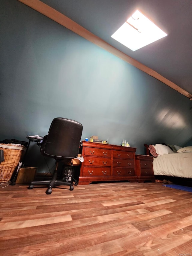 home office featuring a skylight and light hardwood / wood-style flooring