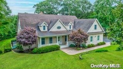 view of front of property featuring covered porch and a front yard