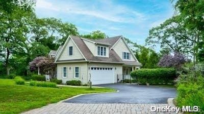 view of front of property featuring a garage and a front lawn