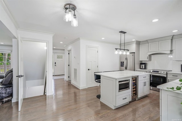 kitchen with a center island, light stone counters, light wood-type flooring, and appliances with stainless steel finishes