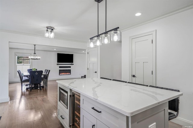 kitchen with a kitchen island, dark wood-type flooring, white cabinetry, wine cooler, and hanging light fixtures