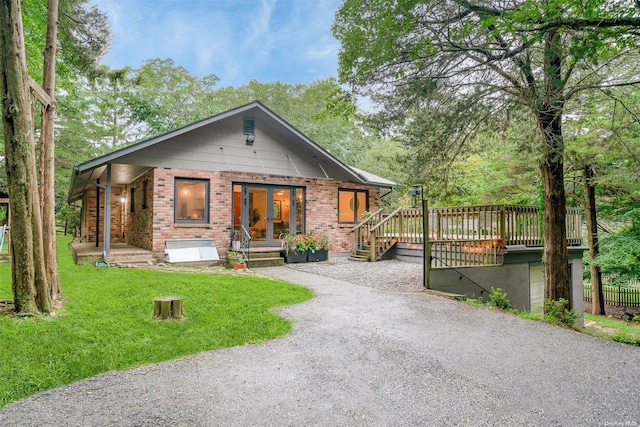 view of front of home with a front yard and a wooden deck