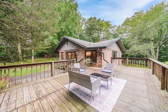 deck featuring an outdoor living space with a fire pit