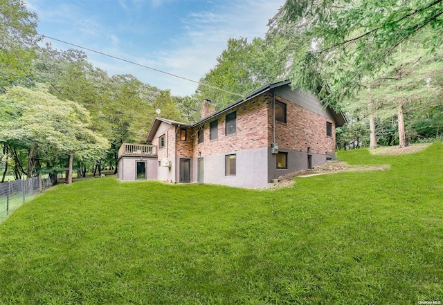 back of house with a deck and a yard