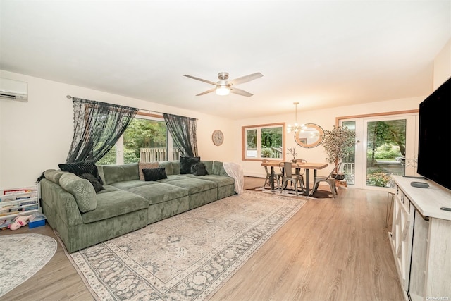 living room with light wood-type flooring, a wall mounted air conditioner, and a wealth of natural light