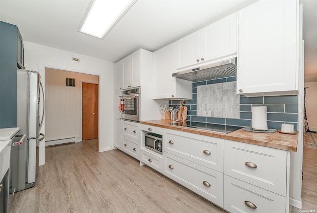 kitchen featuring white cabinets, wood counters, a baseboard heating unit, stainless steel appliances, and tasteful backsplash