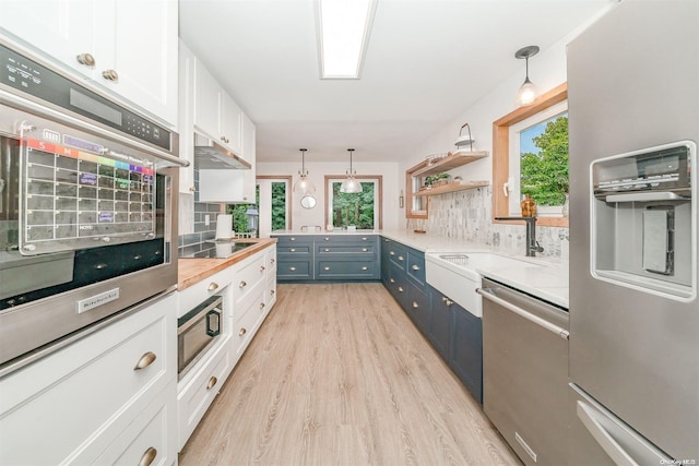 kitchen with blue cabinets, decorative light fixtures, white cabinetry, and appliances with stainless steel finishes