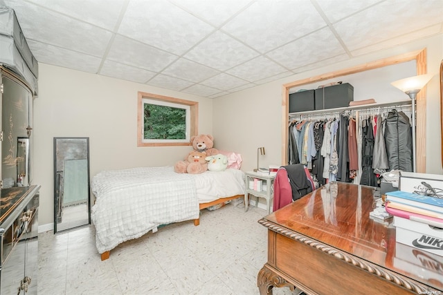 bedroom with a paneled ceiling and a closet