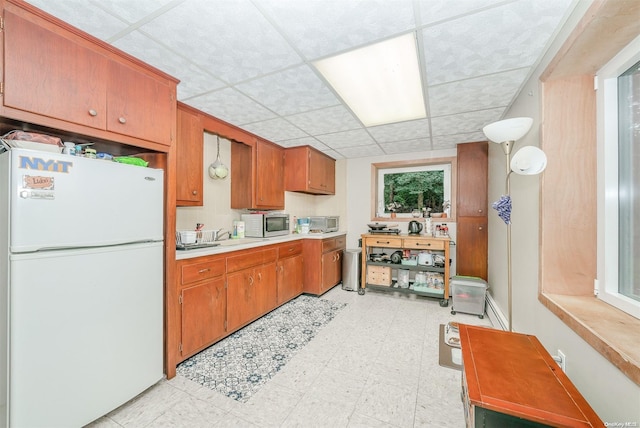 kitchen with a paneled ceiling and white fridge