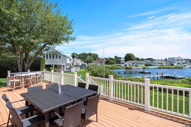 wooden deck featuring a lawn and a water view