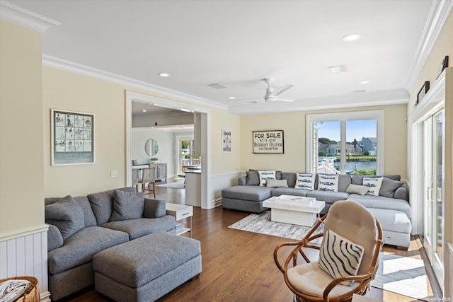 living room featuring ceiling fan, a water view, dark hardwood / wood-style floors, and ornamental molding