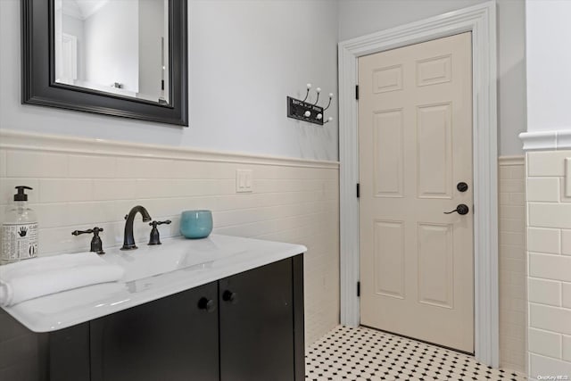 bathroom with vanity and tile walls