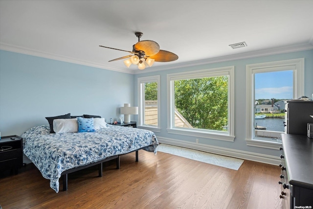 bedroom featuring wood-type flooring, ceiling fan, and crown molding