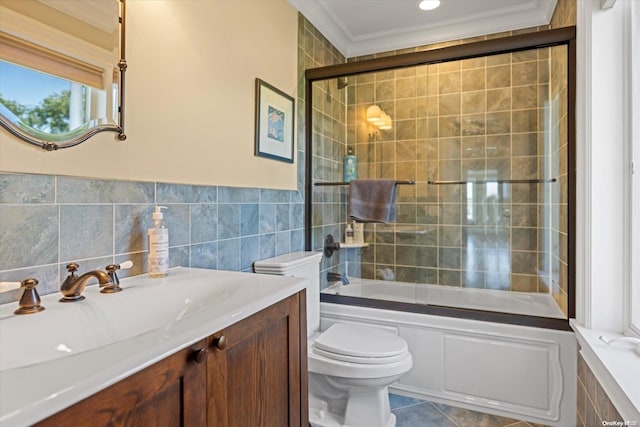 full bathroom featuring tile patterned flooring, enclosed tub / shower combo, crown molding, toilet, and vanity