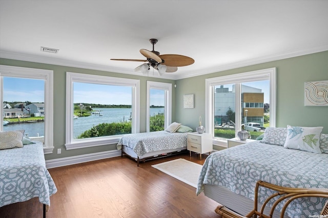 bedroom featuring dark hardwood / wood-style flooring, a water view, ceiling fan, and ornamental molding