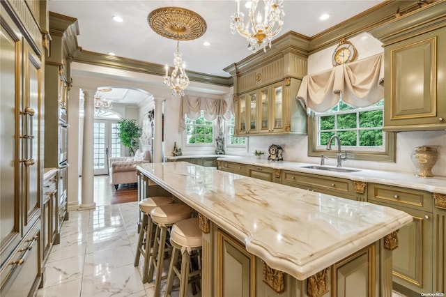 kitchen featuring decorative columns, a wealth of natural light, and a center island