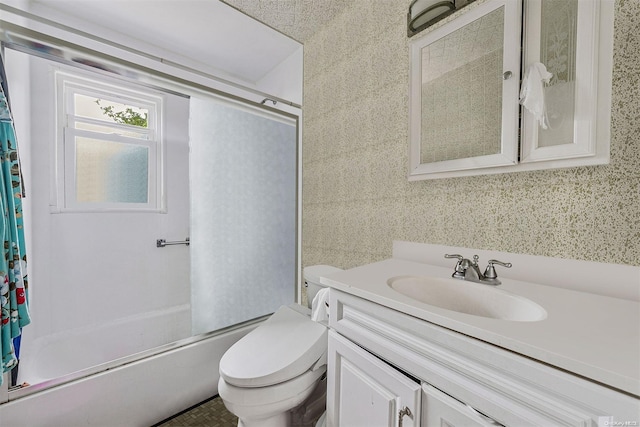 full bathroom featuring toilet, combined bath / shower with glass door, and vanity