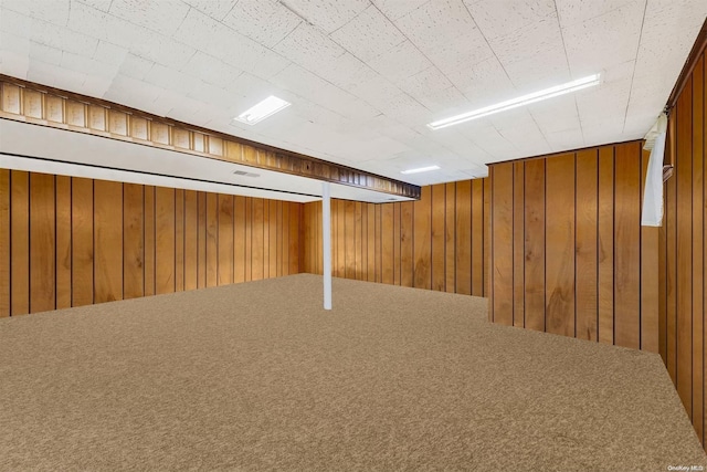 basement with carpet floors and wooden walls