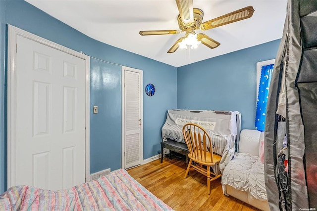 bedroom with a closet, hardwood / wood-style flooring, and ceiling fan